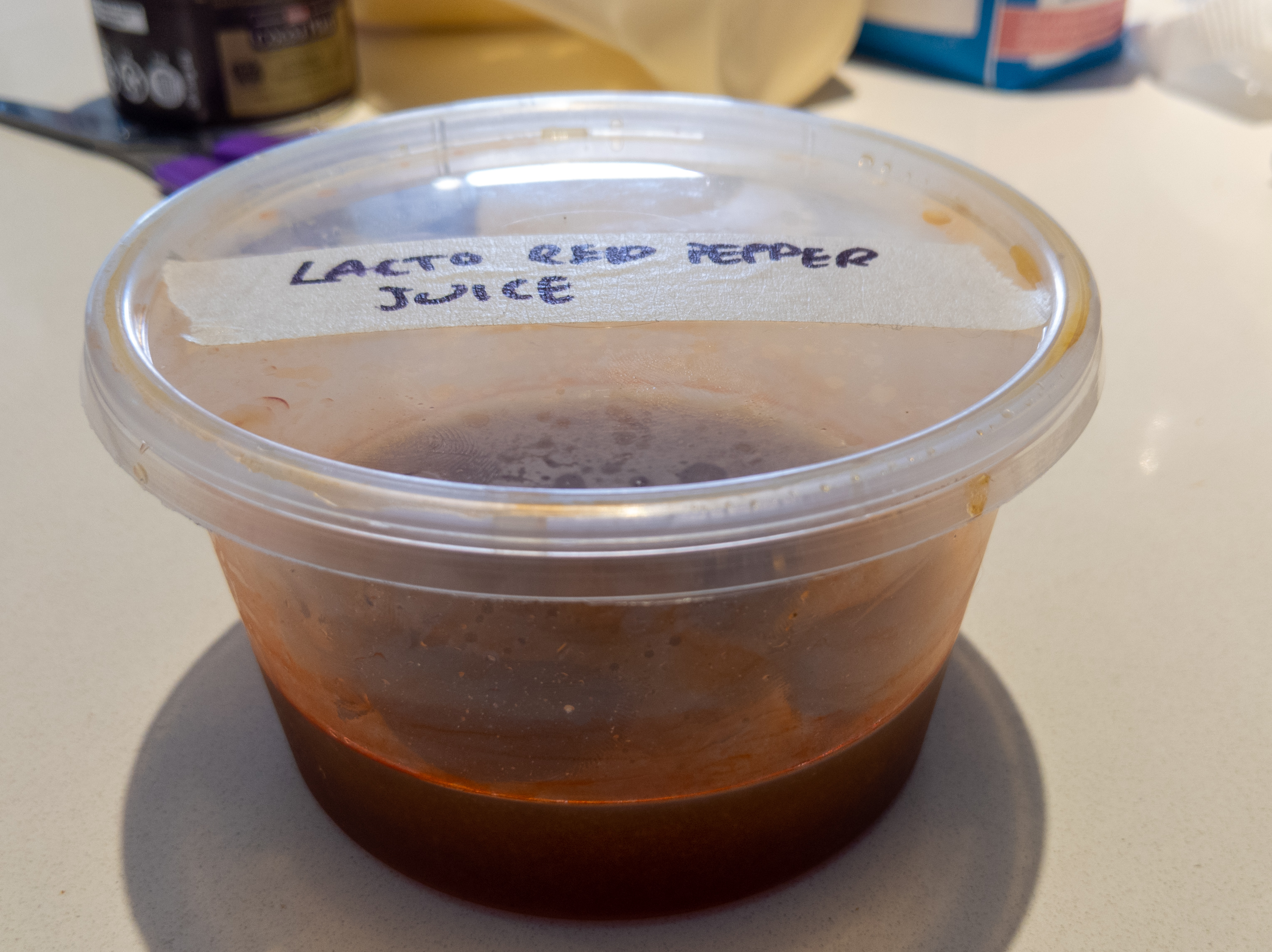 A small container filled with a light red, translucent liquid