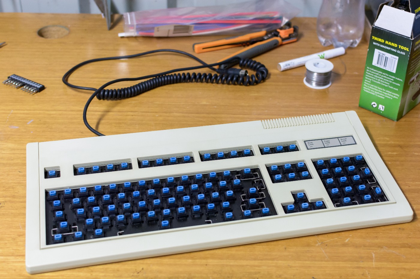 An image of a keyboard with the keycaps removed. The stems of the keycaps are light blue.