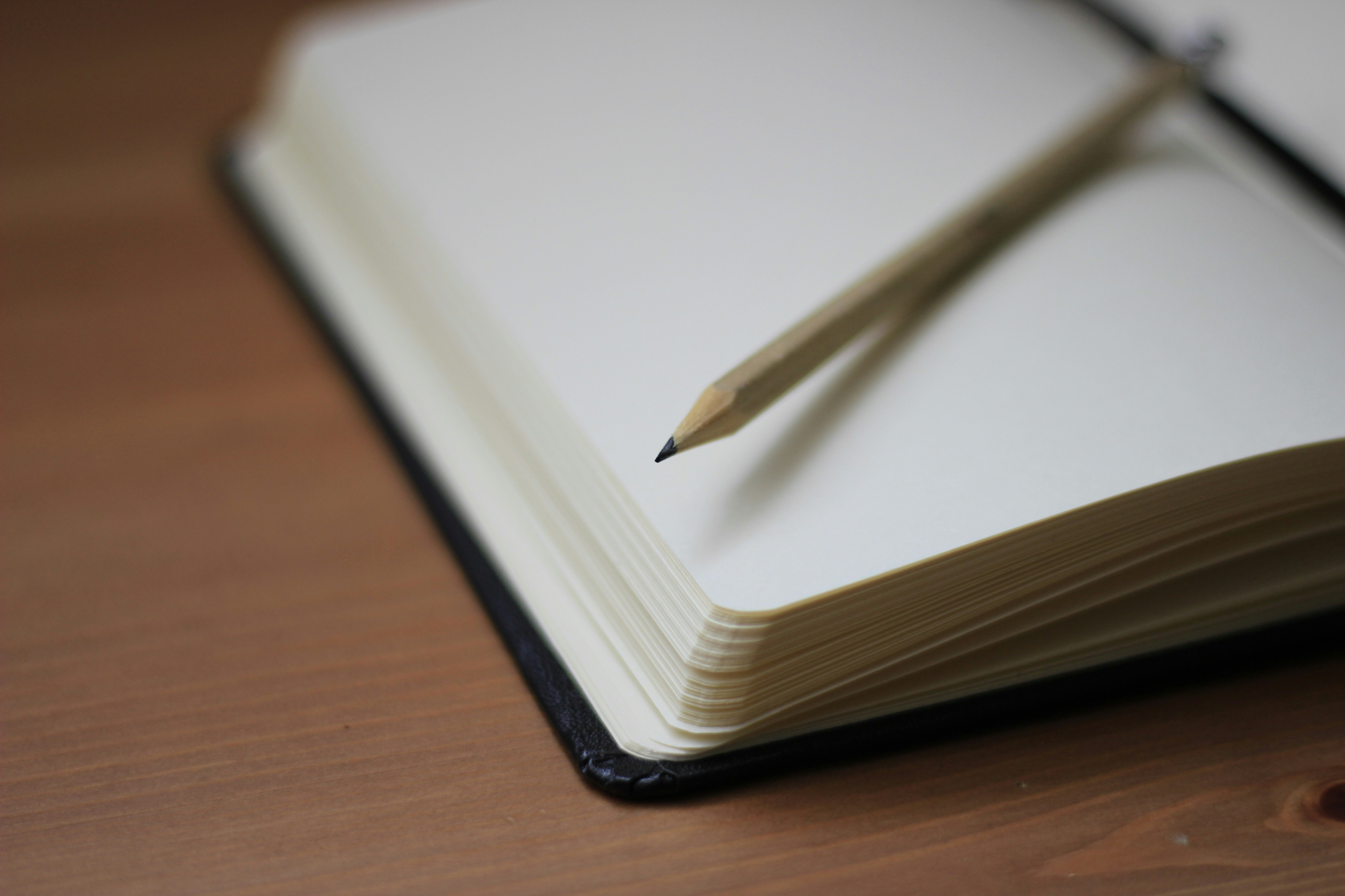 A shallow focus image of a notebook with a pencil on it.