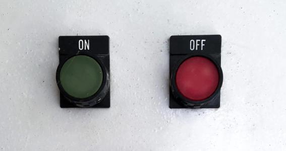 Two buttons attached to a wall. The left button is labelled ON and the right button is labelled OFF.